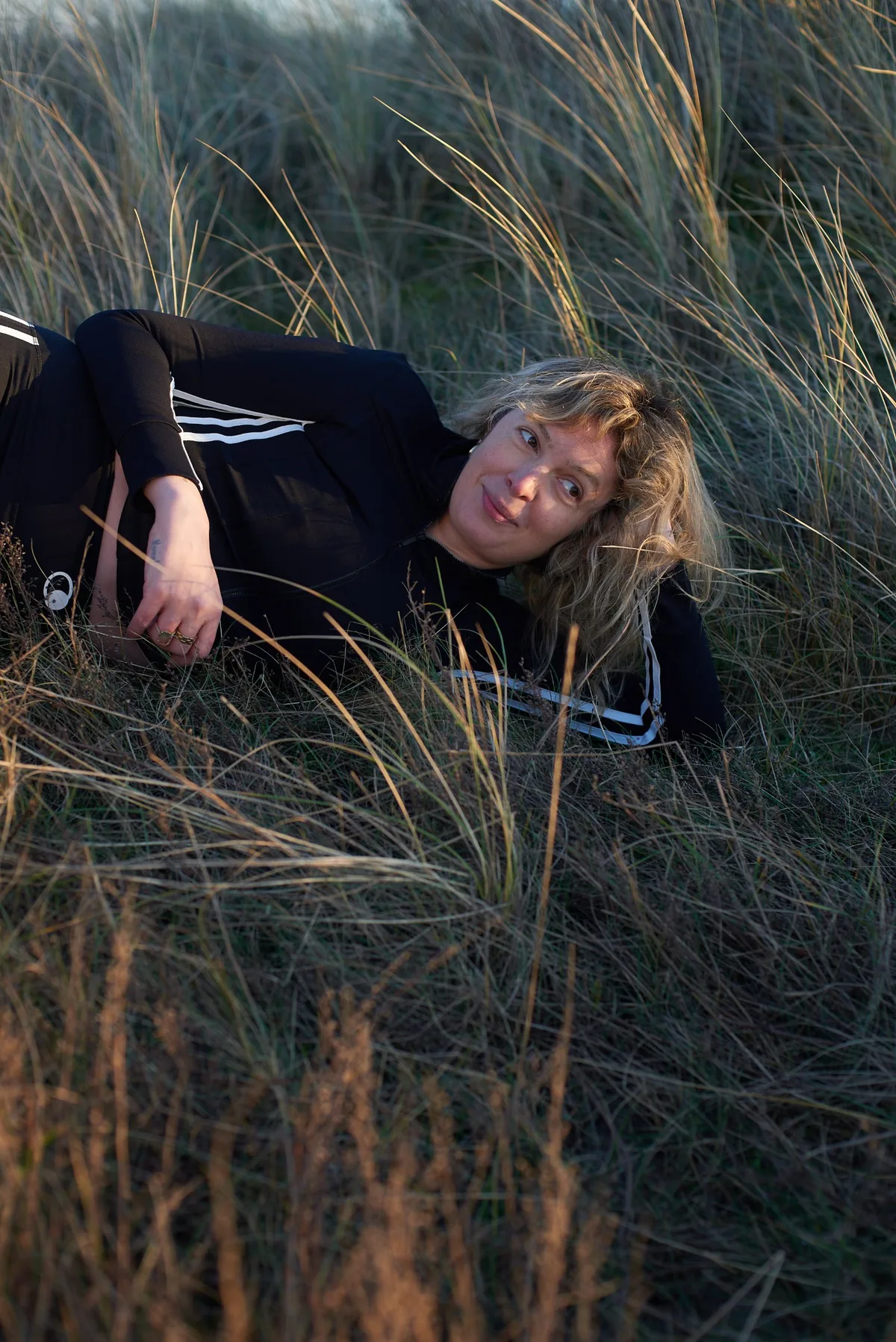 Smiling in the grass in the GRAVITY LINE jacket, the white torso stripes and the circular Moontians mark at the waist