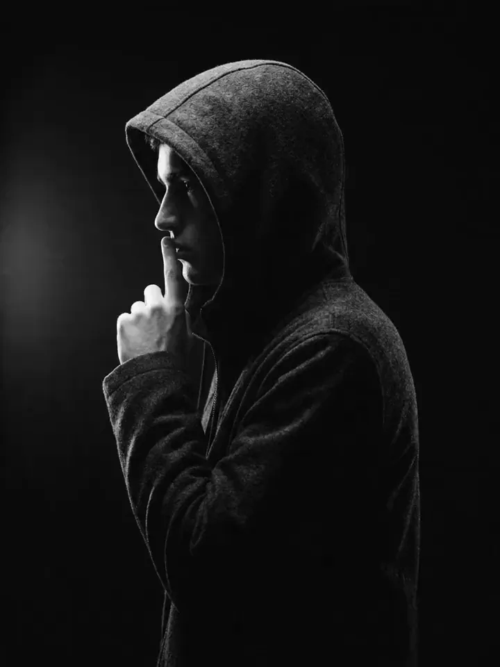 A hooded Moontian, finger to lips