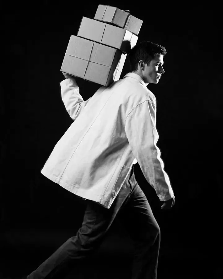 A Moontian striding forward with a stack of parcels