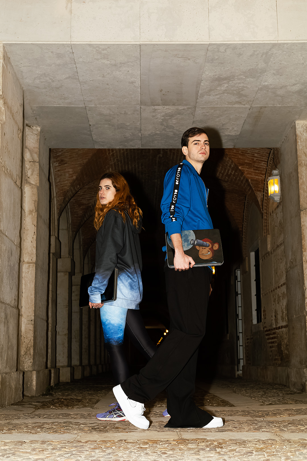 Two Moontians under a stone archway at night
