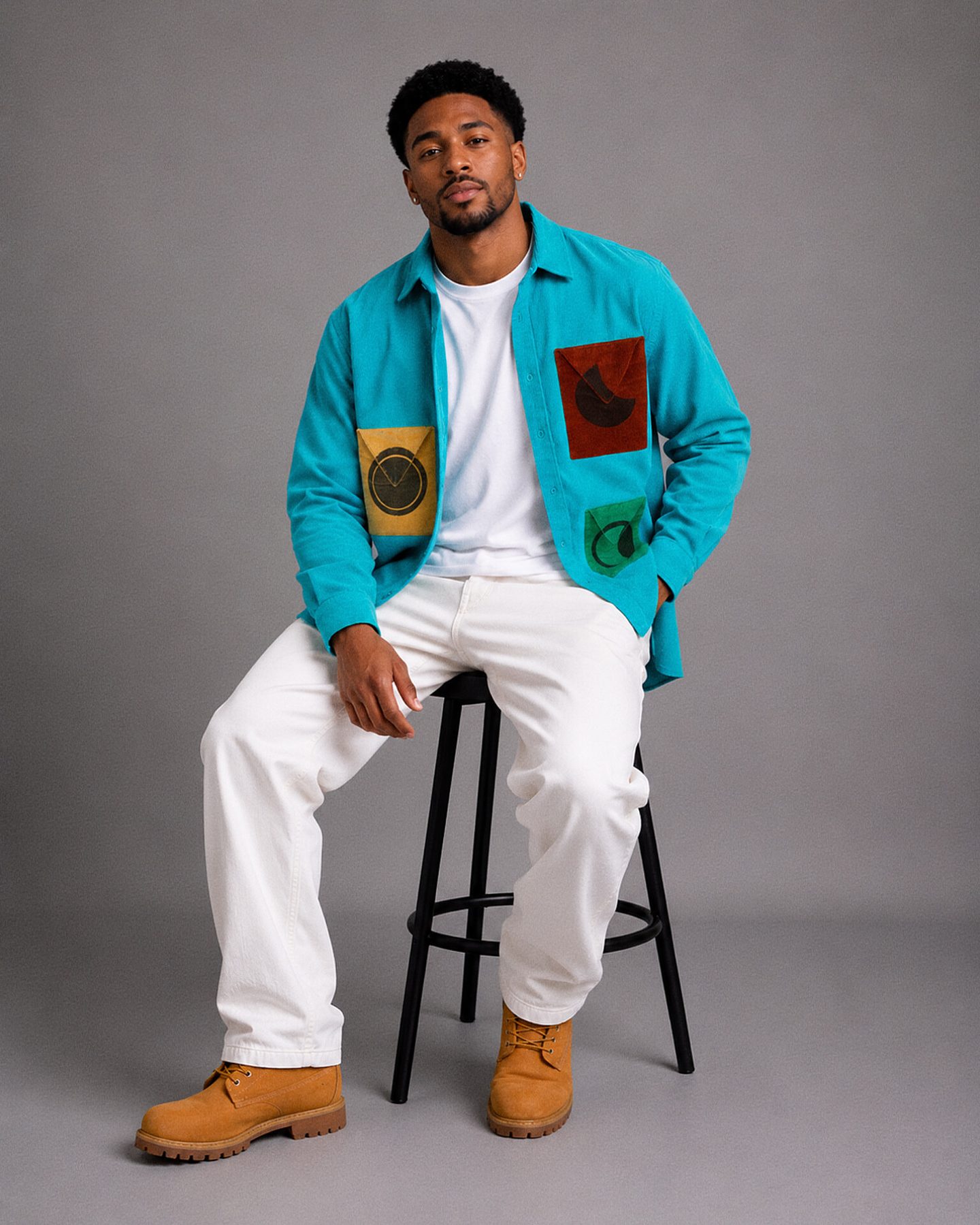 Model seated in the SS26 Tri-Phase shirt in teal, with contrast moon-phase pockets