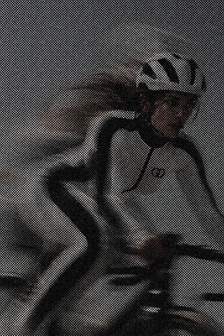 Orbital Panel Jumpsuit in grey halftone, on a bicycle